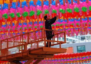 Jogyaesa worker attaches names of sponsors to individual lanterns in preparaton for Buddha's birthday.  Photo by Steebu