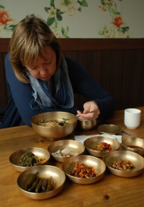 Martha eating mook soup from brass bowls in Mungyeong.